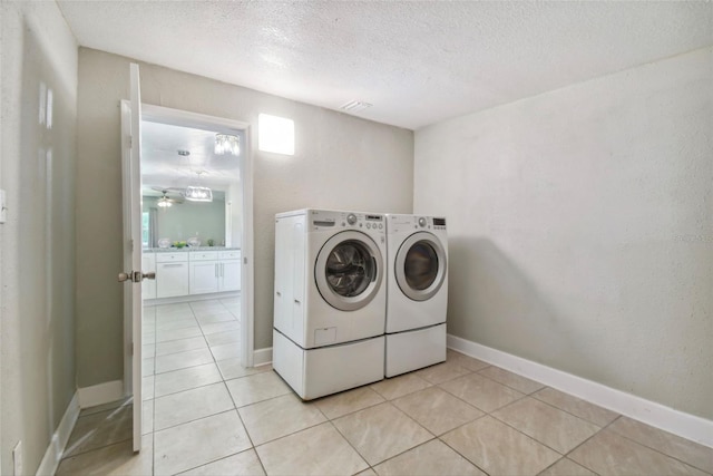 laundry room with washer and dryer, light tile patterned flooring, a textured ceiling, and ceiling fan