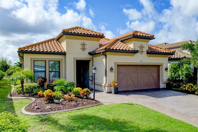 mediterranean / spanish-style house with a garage and a front lawn