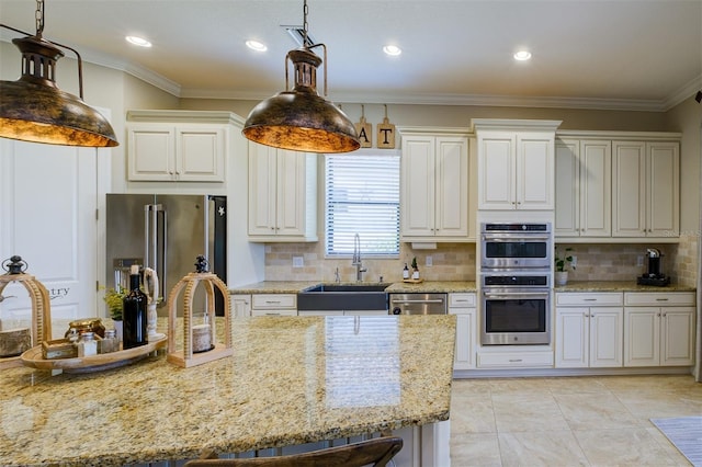 kitchen with decorative backsplash, appliances with stainless steel finishes, light stone countertops, and hanging light fixtures