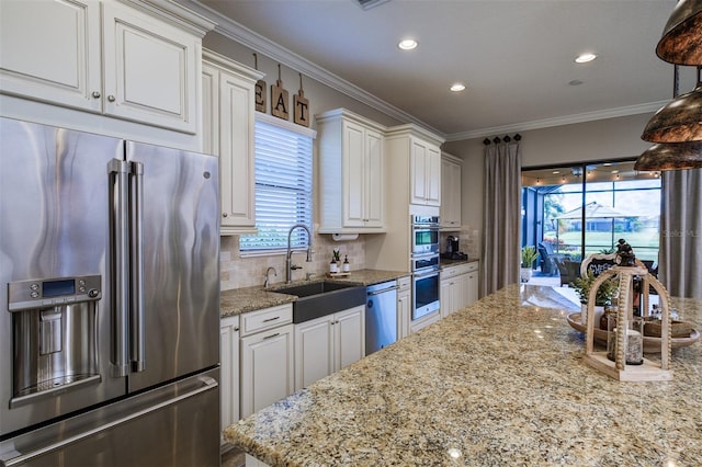 kitchen with light stone counters, sink, white cabinetry, and stainless steel appliances