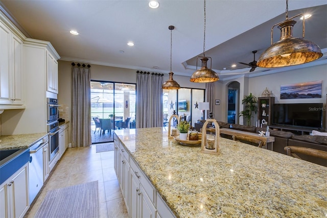 kitchen featuring white cabinetry, ceiling fan, light stone countertops, hanging light fixtures, and ornamental molding