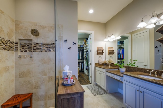 bathroom featuring a tile shower, vanity, and tile patterned floors