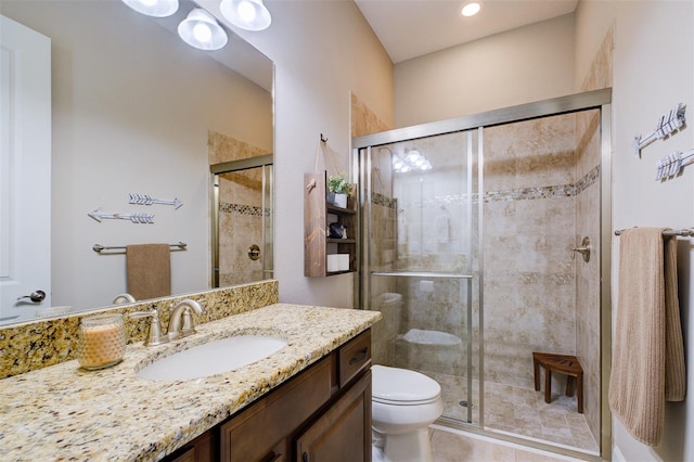 bathroom with tile patterned floors, vanity, toilet, and a shower with shower door