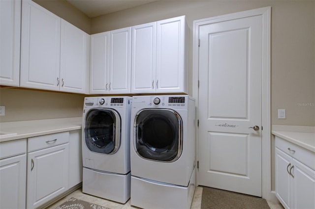 laundry area with cabinets and washing machine and clothes dryer