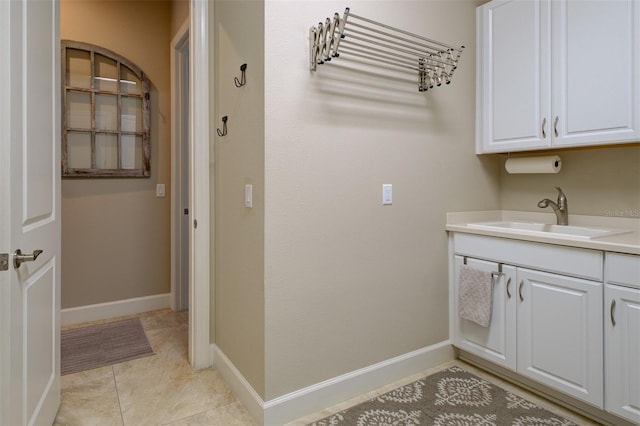 laundry area featuring light tile patterned floors and sink