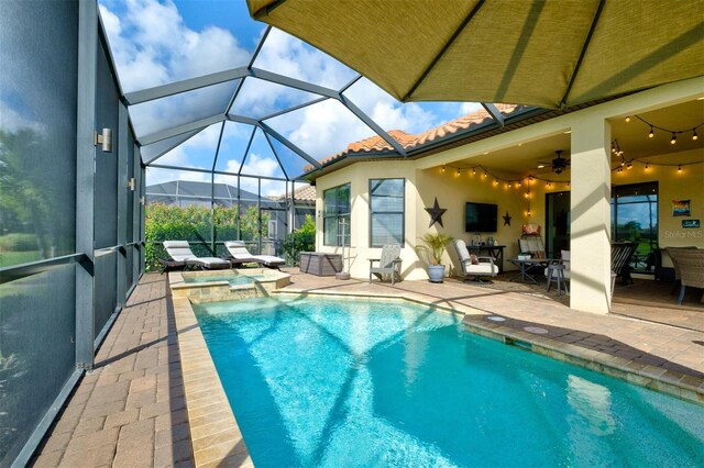 view of pool featuring an in ground hot tub, a patio area, ceiling fan, and a lanai