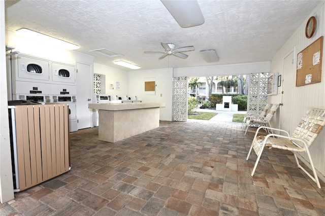 view of patio featuring stacked washer / drying machine, radiator, and ceiling fan