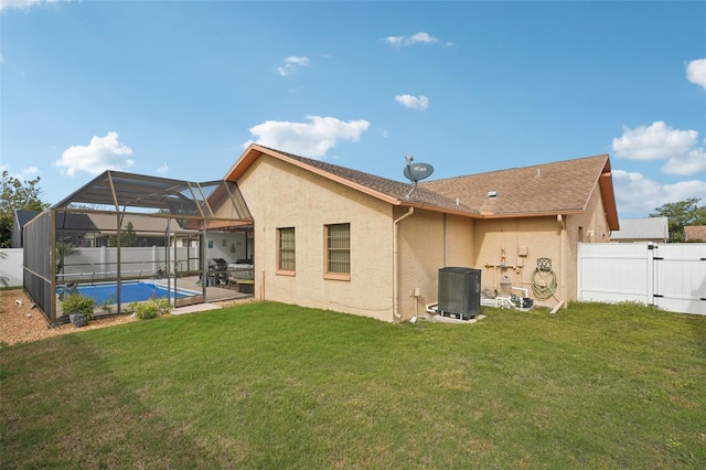 back of property featuring a lawn, cooling unit, a lanai, and a fenced in pool