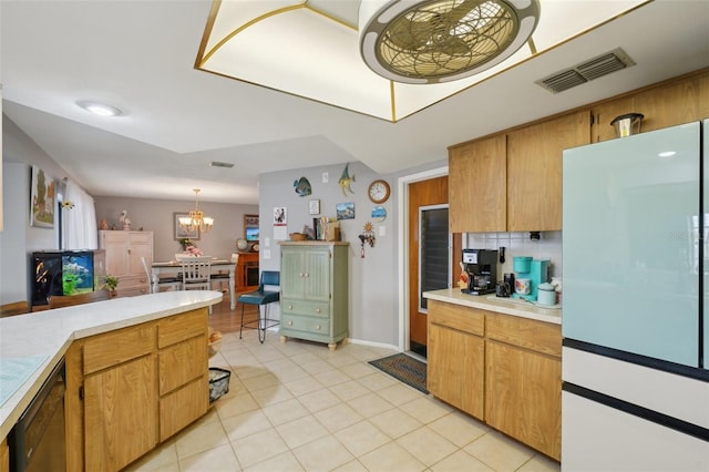 kitchen featuring tasteful backsplash, light tile patterned floors, white refrigerator, a notable chandelier, and hanging light fixtures