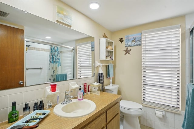 bathroom featuring a healthy amount of sunlight, a shower with curtain, toilet, decorative backsplash, and vanity