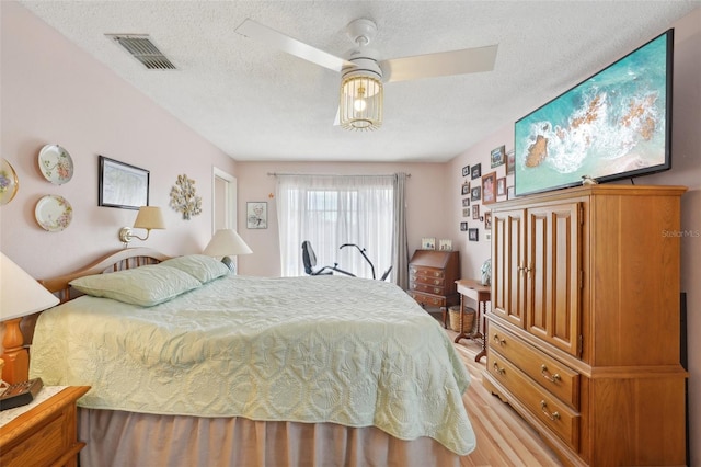 bedroom featuring a textured ceiling, hardwood / wood-style flooring, and ceiling fan