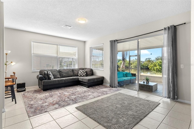 living room with light tile patterned flooring and a textured ceiling