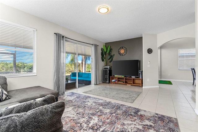 tiled living room featuring a textured ceiling