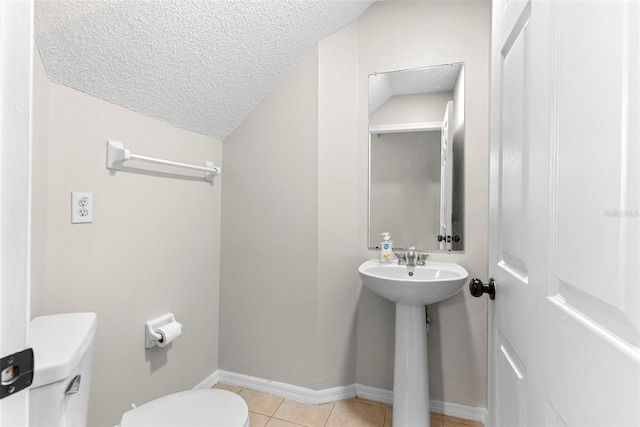 bathroom with tile patterned floors, toilet, and a textured ceiling