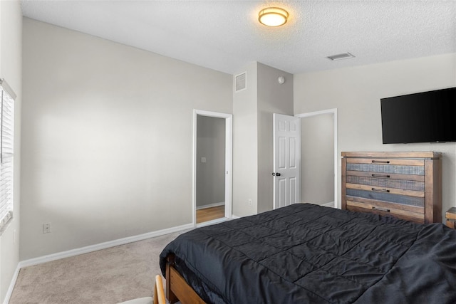 carpeted bedroom with vaulted ceiling and a textured ceiling