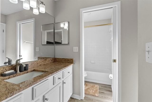 full bathroom featuring shower / bathing tub combination, hardwood / wood-style floors, vanity, and toilet