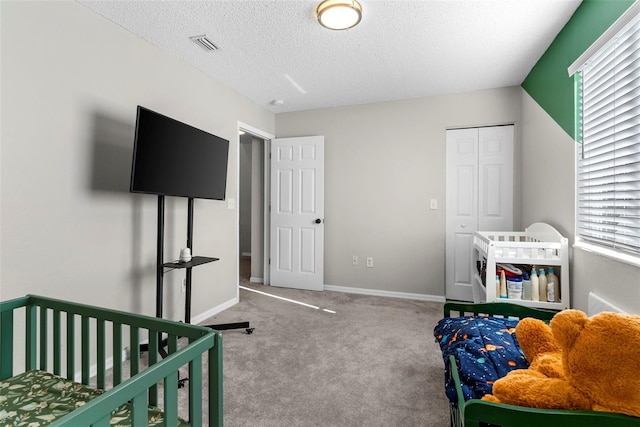 bedroom featuring multiple windows, light carpet, a closet, and a textured ceiling