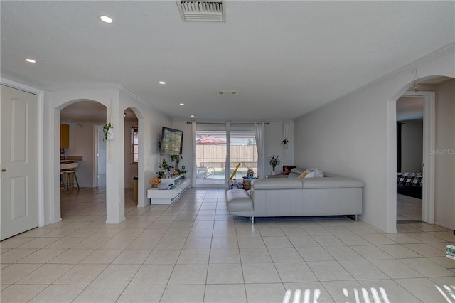 unfurnished living room featuring light tile patterned floors and crown molding