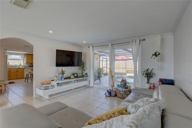 tiled living room with a textured ceiling and crown molding