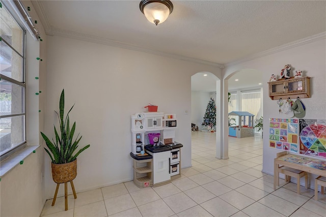 rec room with light tile patterned floors and crown molding