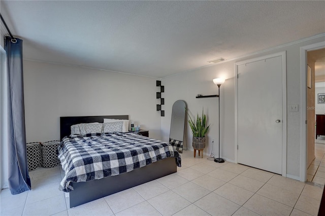 bedroom with a textured ceiling and light tile patterned flooring