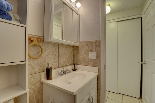 bathroom featuring tile patterned floors, vanity, a textured ceiling, and tasteful backsplash