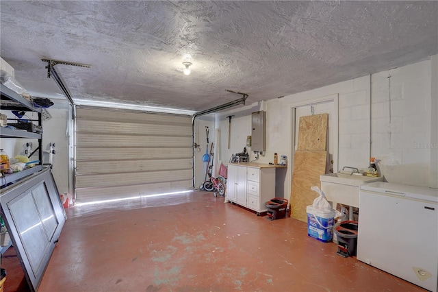 garage featuring refrigerator, sink, and electric panel