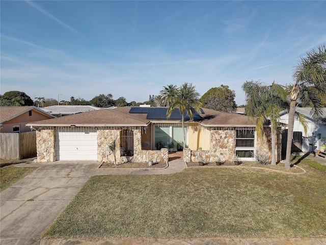 ranch-style house with a garage, a front yard, and solar panels