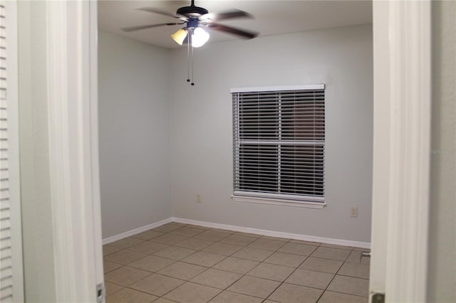 tiled spare room with ceiling fan