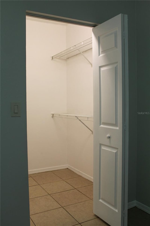 walk in closet with light tile patterned floors