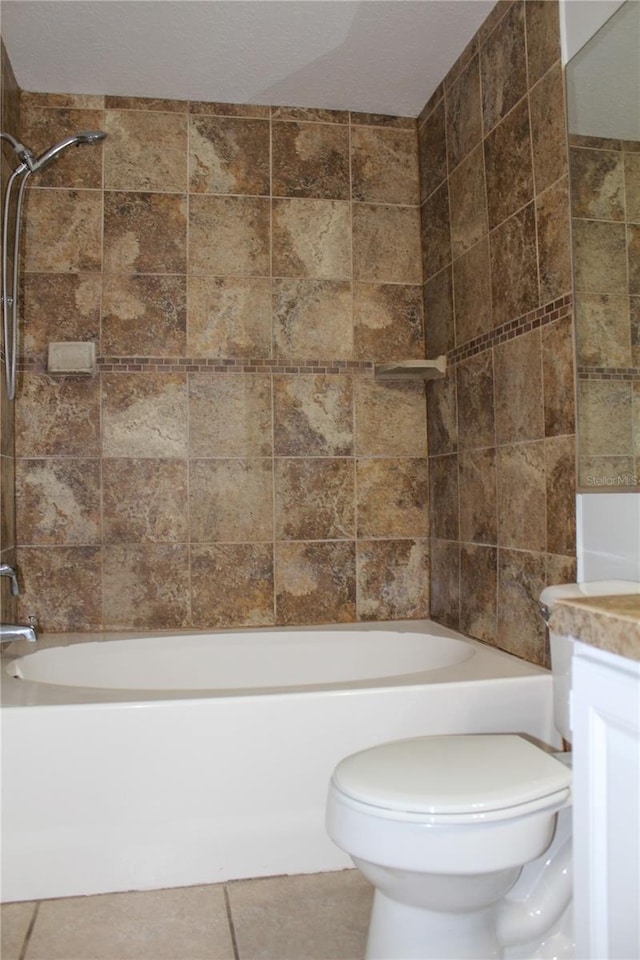 full bathroom featuring tile patterned flooring, vanity, toilet, and tiled shower / bath combo