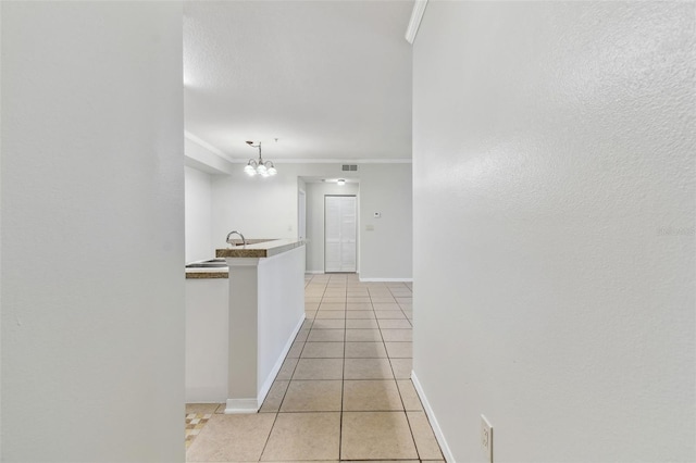 5606 Pinnacle Heights Cir Unit 304, Tampa, FL 33624 - corridor featuring crown molding, light tile patterned floors, a chandelier, and baseboards