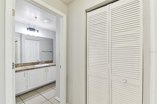 5606 Pinnacle Heights Cir Unit 304, Tampa, FL 33624 - bathroom with tile patterned floors, vanity, a closet, baseboards, and a textured ceiling