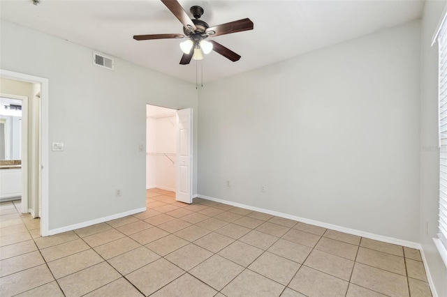 5606 Pinnacle Heights Cir Unit 304, Tampa, FL 33624 - unfurnished bedroom with light tile patterned flooring, a spacious closet, baseboards, a closet, and a ceiling fan