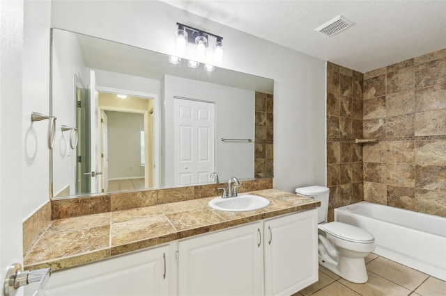 5606 Pinnacle Heights Cir Unit 304, Tampa, FL 33624 - full bath with toilet, tile patterned flooring, vanity, a textured ceiling, and washtub / shower combination