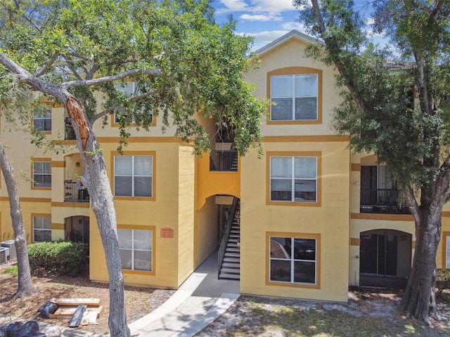 5606 Pinnacle Heights Cir Unit 304, Tampa, FL 33624 - view of property featuring stairway, central AC unit, and stucco siding