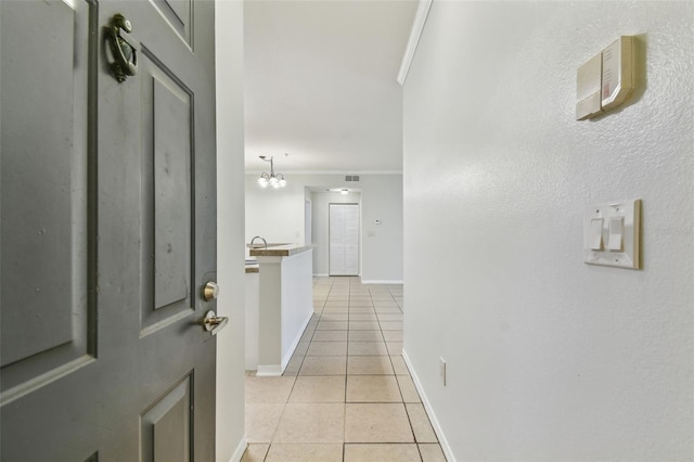 5606 Pinnacle Heights Cir Unit 304, Tampa, FL 33624 - corridor with light tile patterned floors, ornamental molding, a chandelier, and baseboards