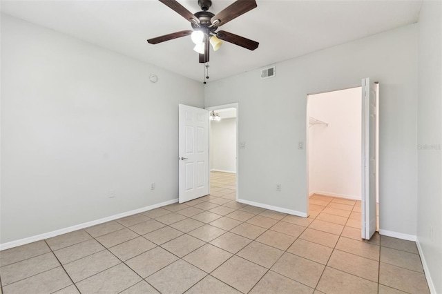 5606 Pinnacle Heights Cir Unit 304, Tampa, FL 33624 - unfurnished bedroom with light tile patterned flooring, a spacious closet, baseboards, and ceiling fan