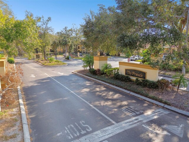 5606 Pinnacle Heights Cir Unit 304, Tampa, FL 33624 - view of asphalt road featuring curbs and view of wooded area