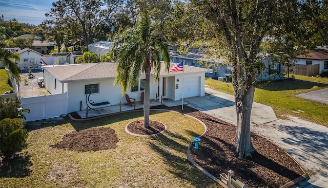 view of front facade with a front yard, a garage, and a patio