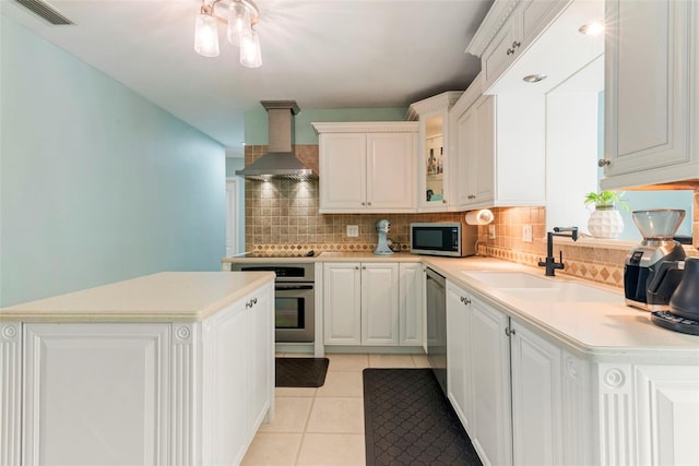 kitchen featuring appliances with stainless steel finishes, light tile patterned floors, sink, white cabinetry, and extractor fan