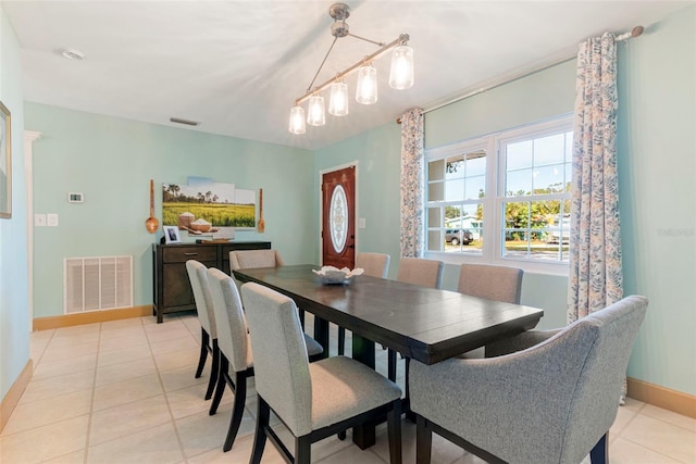 tiled dining area with an inviting chandelier