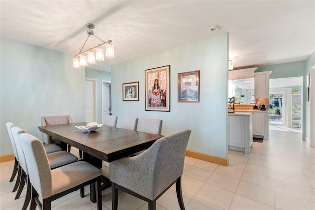 tiled dining space with a chandelier