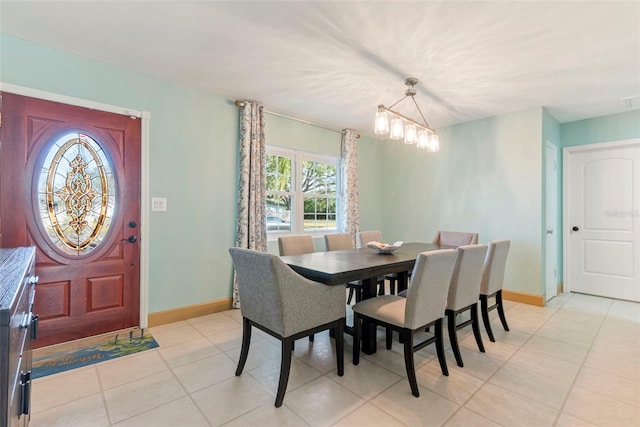 dining area featuring light tile patterned floors and a notable chandelier