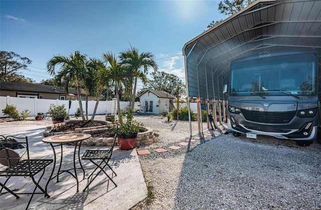 view of patio / terrace featuring an outbuilding and a carport