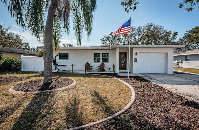 ranch-style house featuring covered porch, a front lawn, and a garage