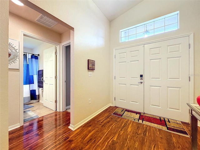 foyer featuring hardwood / wood-style flooring and vaulted ceiling