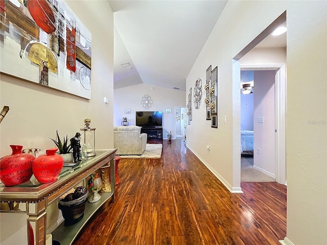 hallway featuring dark hardwood / wood-style flooring and vaulted ceiling