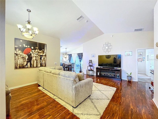 living room featuring dark wood-type flooring, lofted ceiling, and a notable chandelier