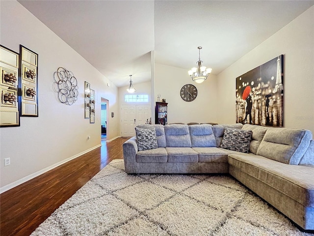 living room with a chandelier, hardwood / wood-style floors, and lofted ceiling